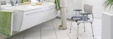 Invacare Sorrento silla de ducha con abertura higiénica, con 4 patas abatibles. Incorpora reposabrazos y respaldo.